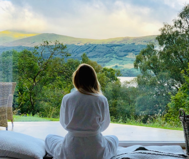 A guest in a robe looking out over the highland view from the cabin deck