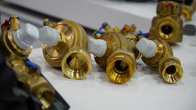 Close-up of brass thermostatic radiator valves and fittings laid out ready for a job